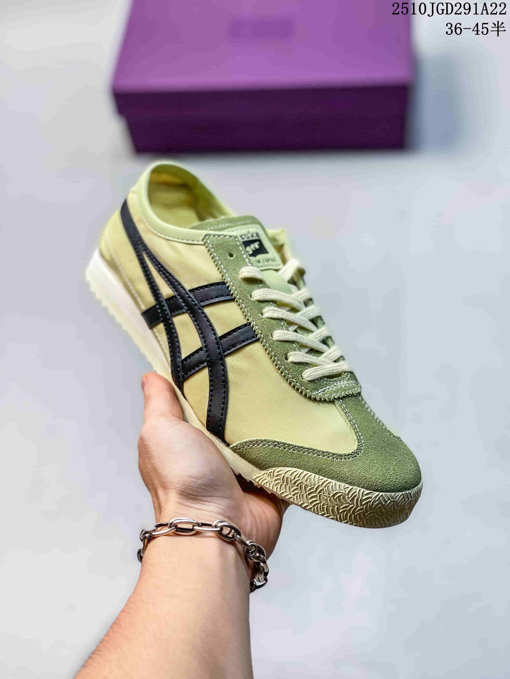 Pale yellow and olive green Onitsuka Tiger sneaker held in hand, showing dark contrast stripes and tonal paneling.