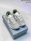 Pair of green and white New Balance 574 sneakers displayed on a shoebox.