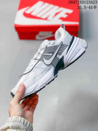 Side profile highlighting the layered panels, large side logo, sculpted midsole, and black outsole.