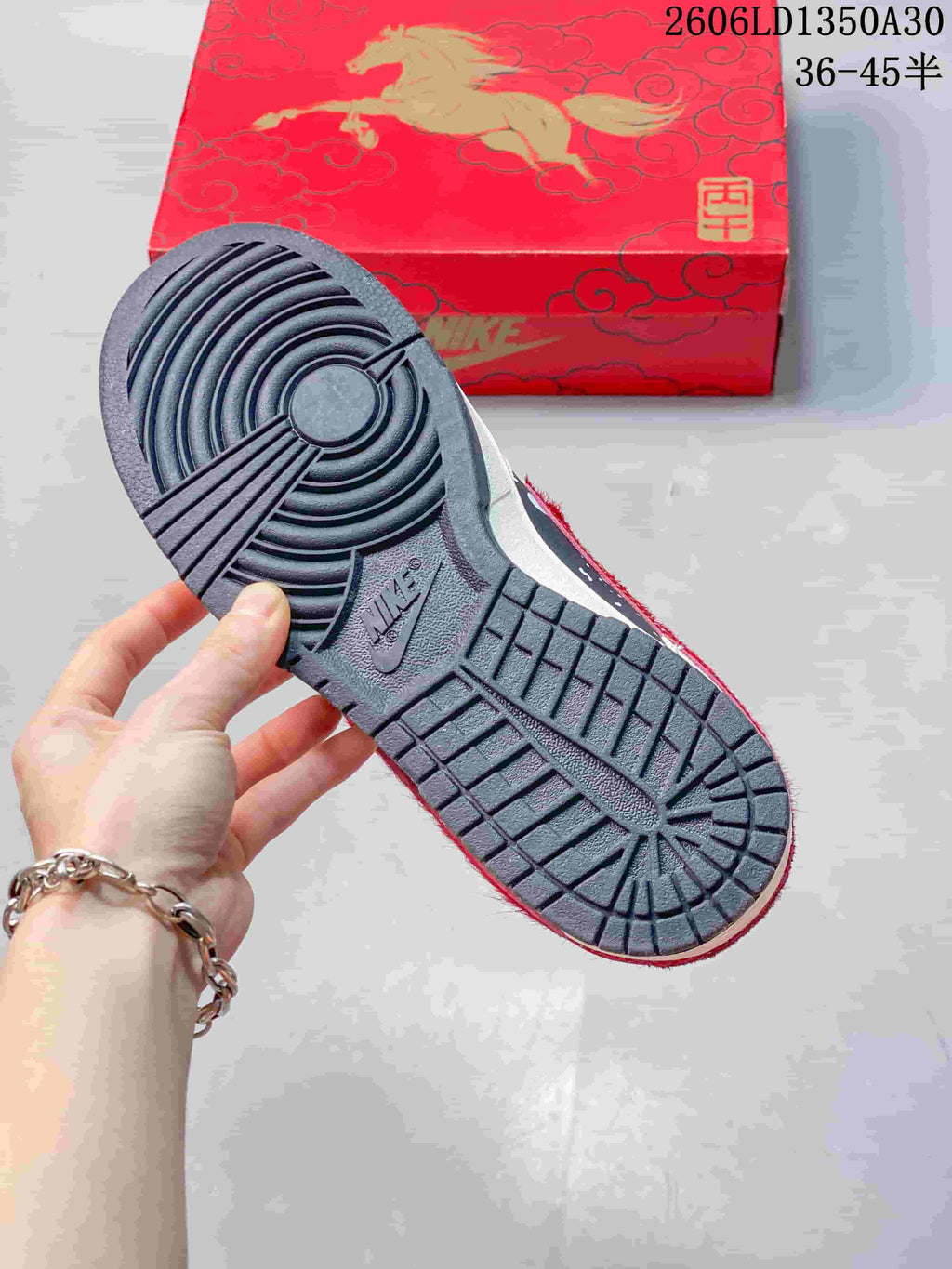Outsole of a Nike SB Dunk Low sneaker beside a red horse-themed box
