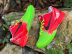 Side views of red and green Nike Kobe 6 basketball shoes showing textured uppers and heel details