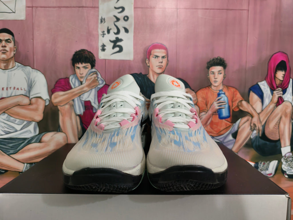 Front view of gray-blue Nike basketball shoes with white laces and pink details.