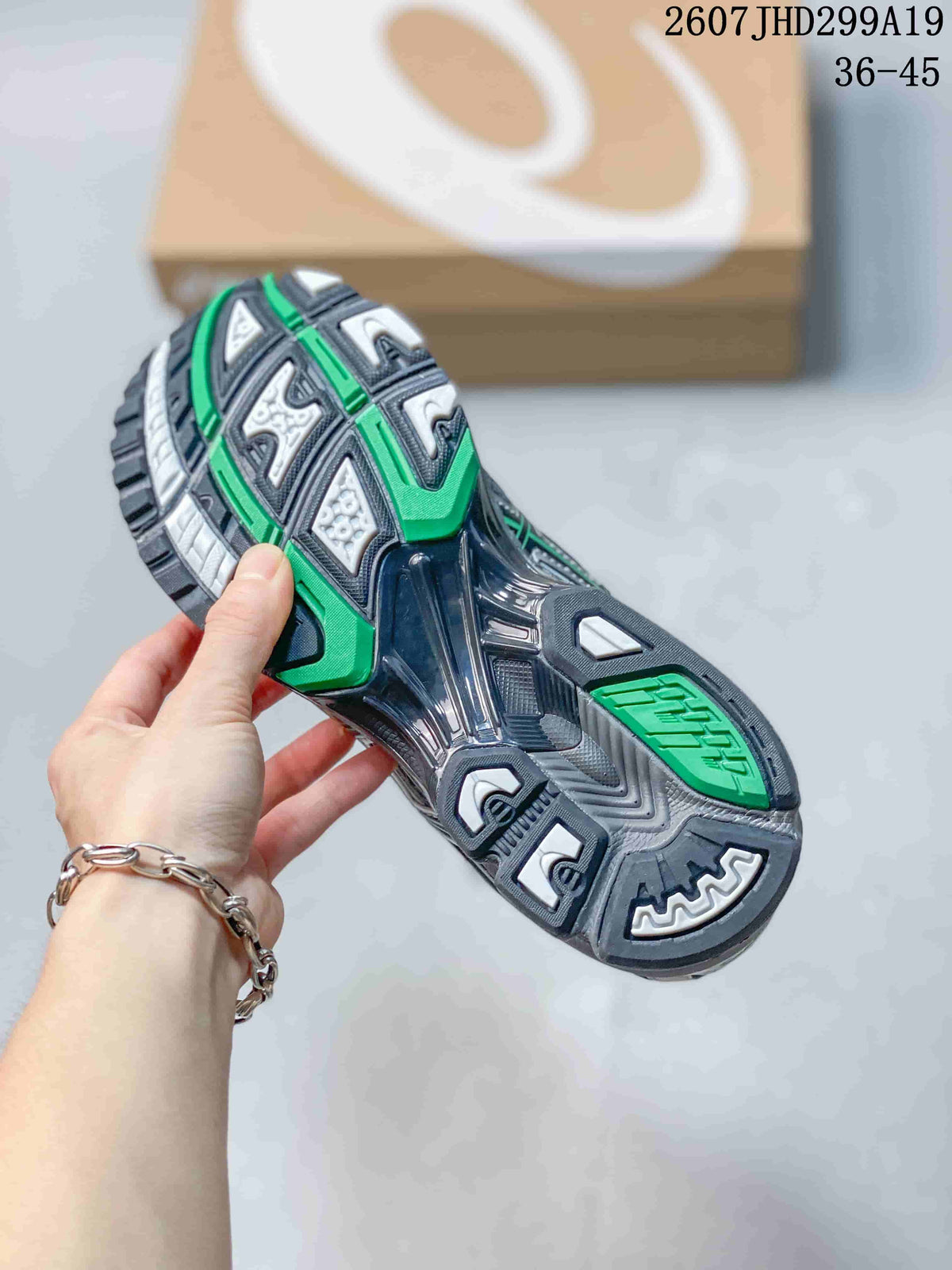 Close-up of the patterned outsole with dark gray, silver, green and white sections.