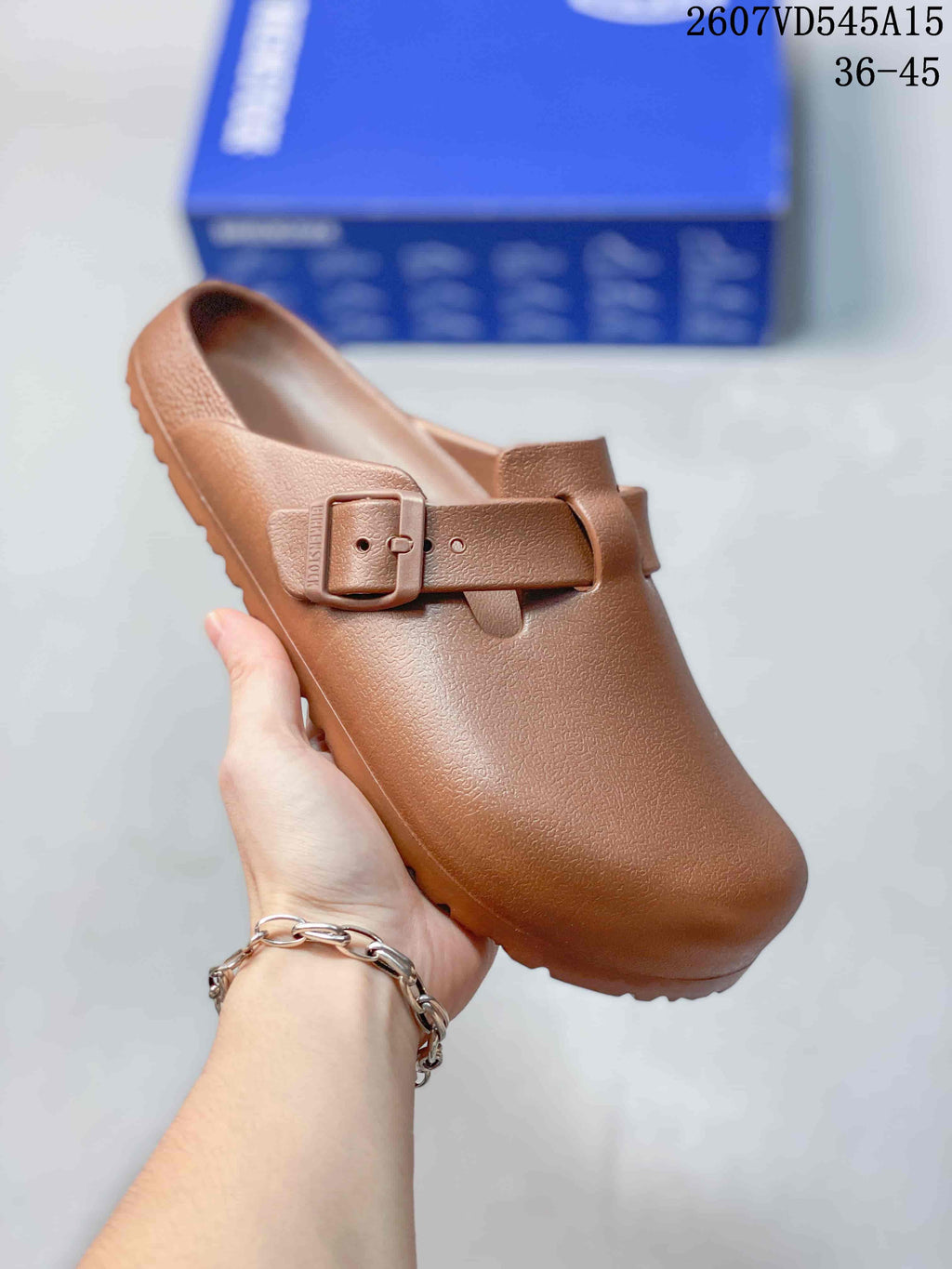 Brown closed-toe buckle sandal shown from an angled front view.