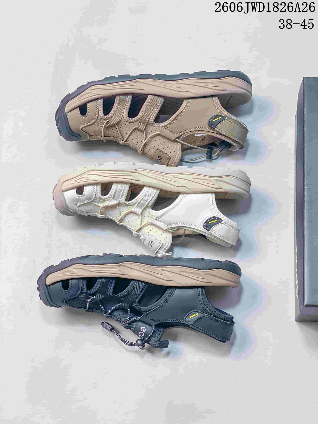 Beige, off-white, and dark navy open-toe sandals displayed in side profile.