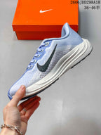 Side profile of the light blue and white Nike running shoe showing the black Swoosh, lace system and layered white midsole.
