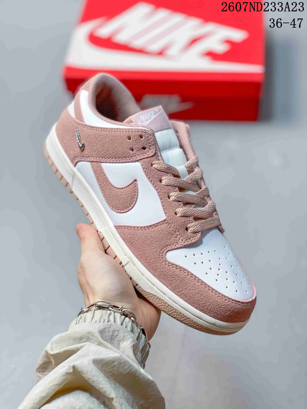 Close-up side view of a white and pink low-top sneaker with a perforated toe box and contrasting outsole.