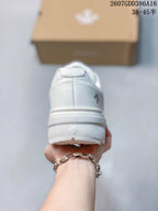 Rear view of a white sneaker showing the padded heel, layered midsole, and heel branding details.