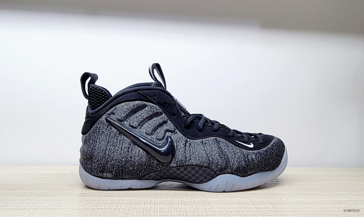 Side view highlighting the Swoosh and textured grey upper of the Nike Air Foamposite Pro Fleece