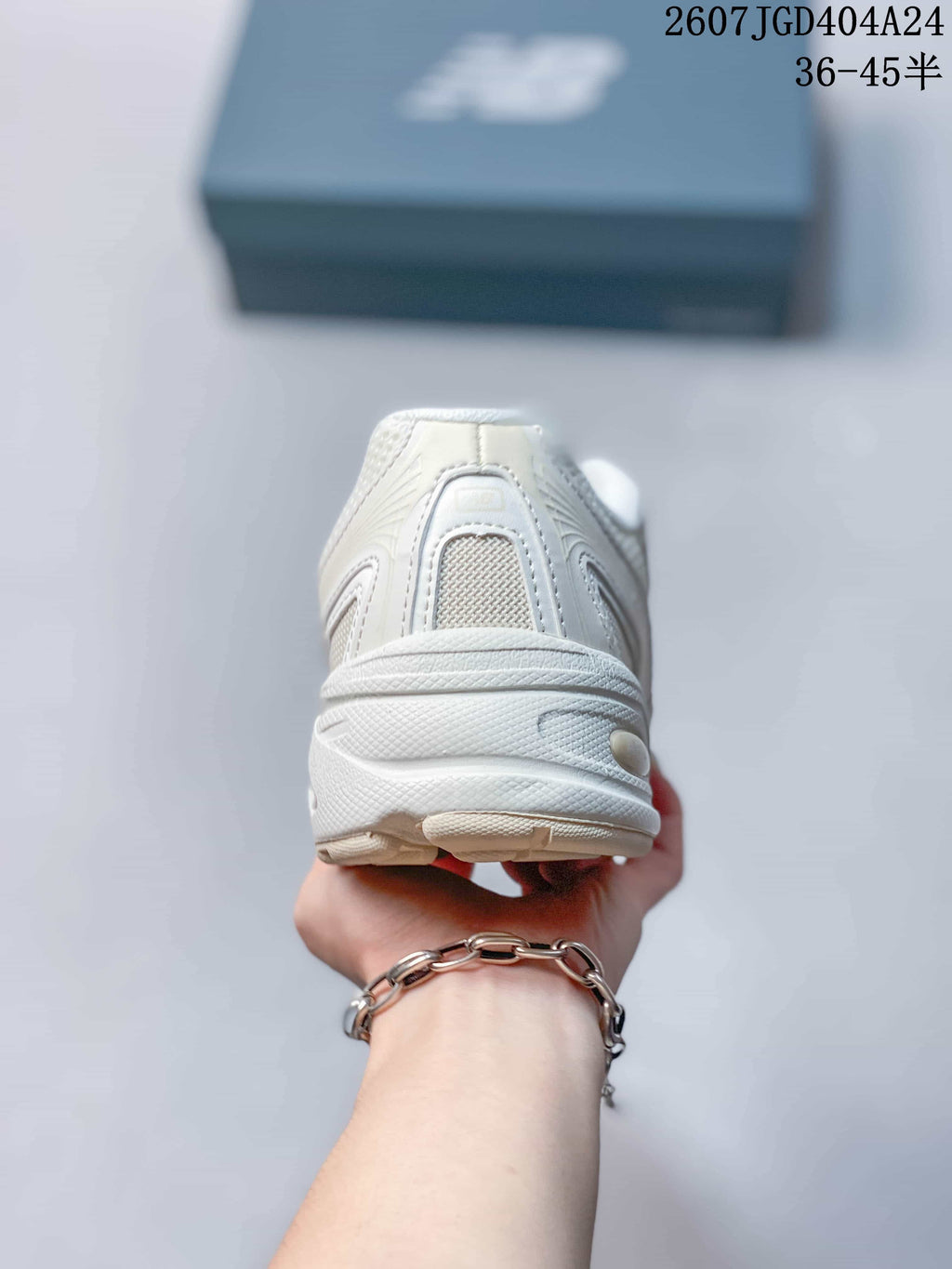 Rear view of the beige sneaker showing the padded heel collar and layered heel construction.