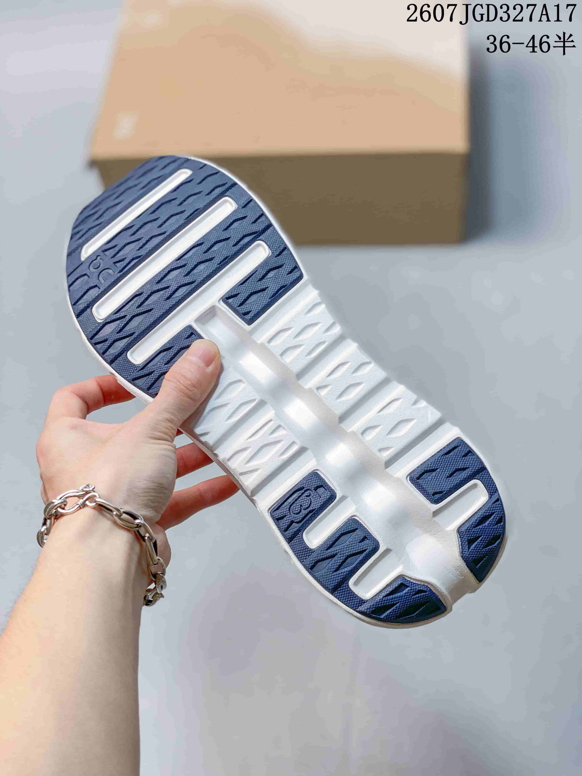 Underside view of a sneaker showing the navy and white outsole with segmented tread sections.