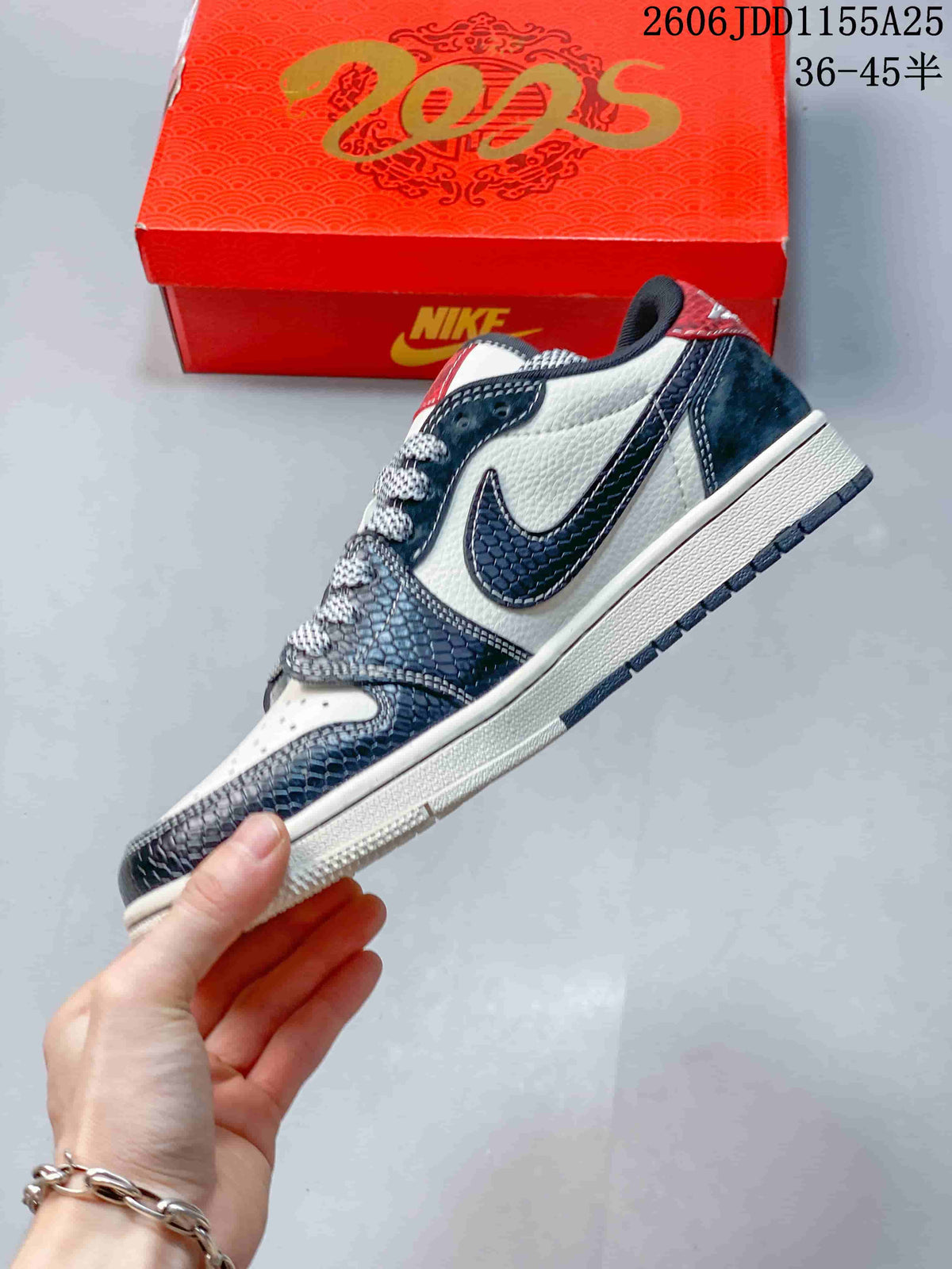 Side view showing the layered white and dark navy upper, patterned overlays and swoosh-shaped side detail.