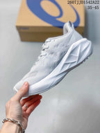 Side profile of the light-colored running shoe showing the textured upper, lace area, sculpted midsole, and outsole design.