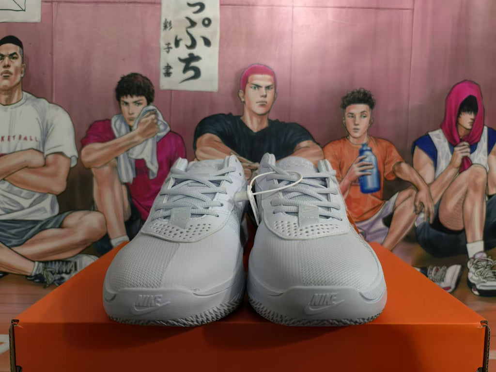 Front view of white Nike basketball shoes with laces and perforated detailing