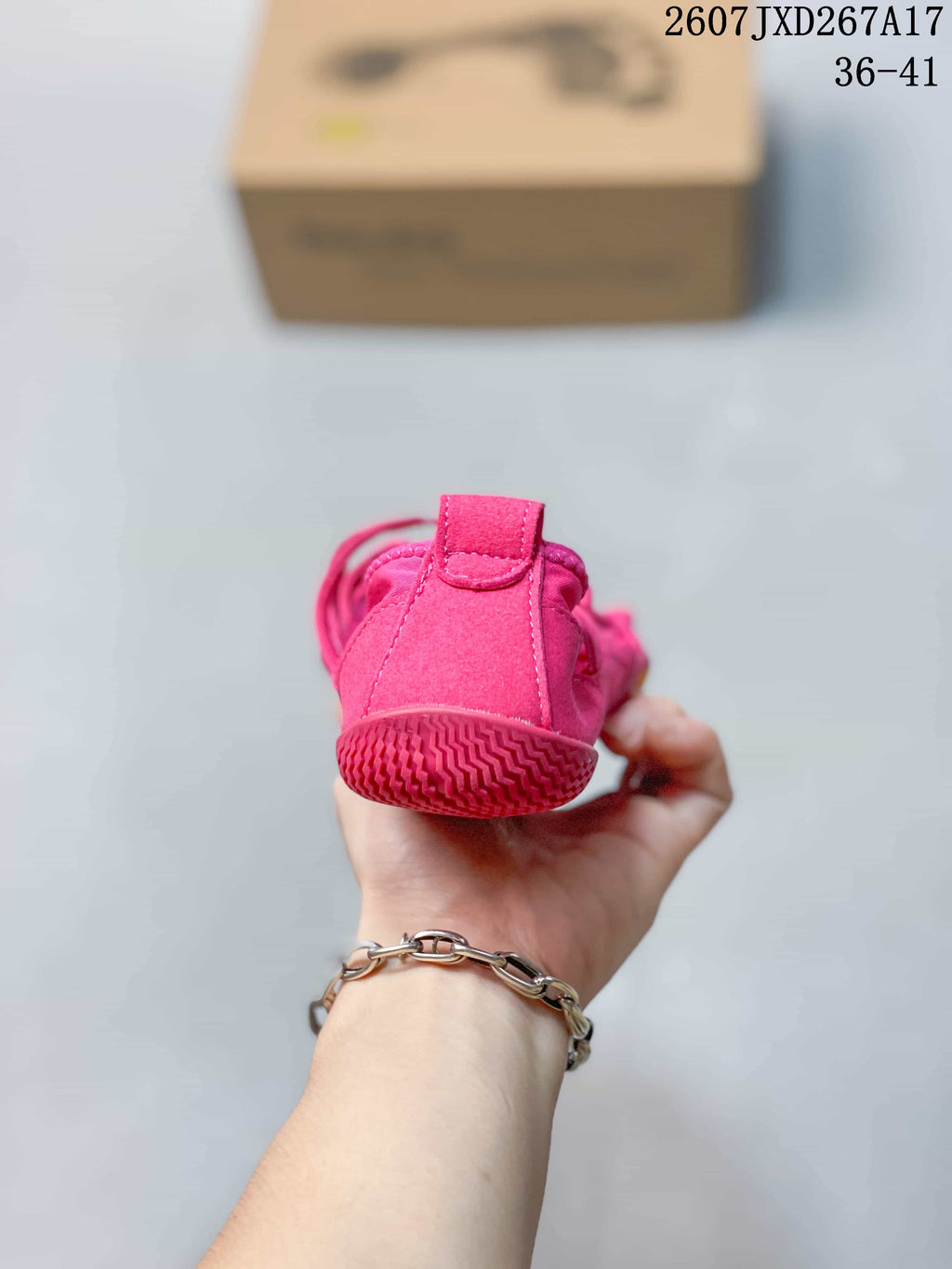 Rear view of a pink low-top five-finger shoe showing the heel pull tab and textured outsole edge.