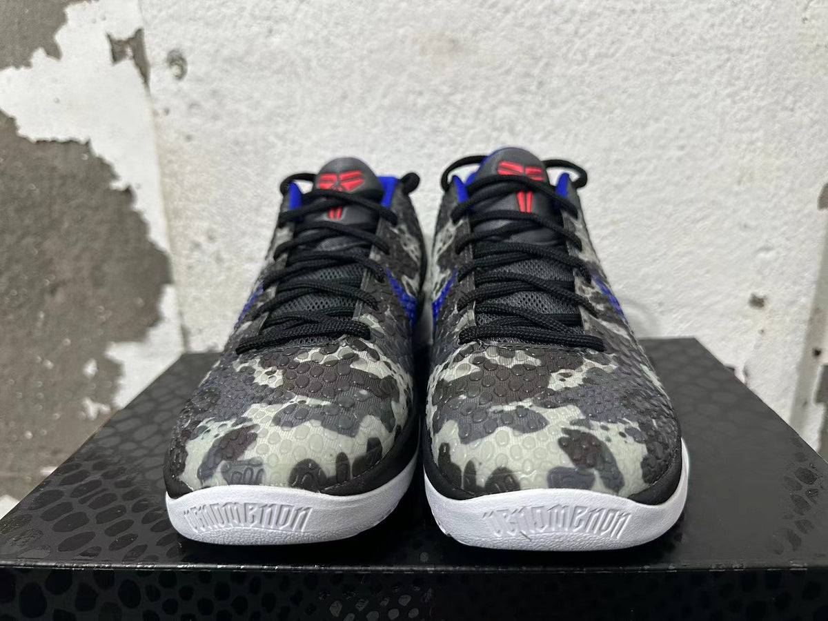 Front view of gray camouflage Nike basketball shoes with black laces, blue accents, and white soles.