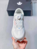 Top view of the white sneaker showing the BOA dial, layered tongue, perforated toe area, and white upper.
