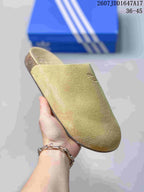 Close-up side view of a light green adidas Adimule mule slide with Trefoil branding.