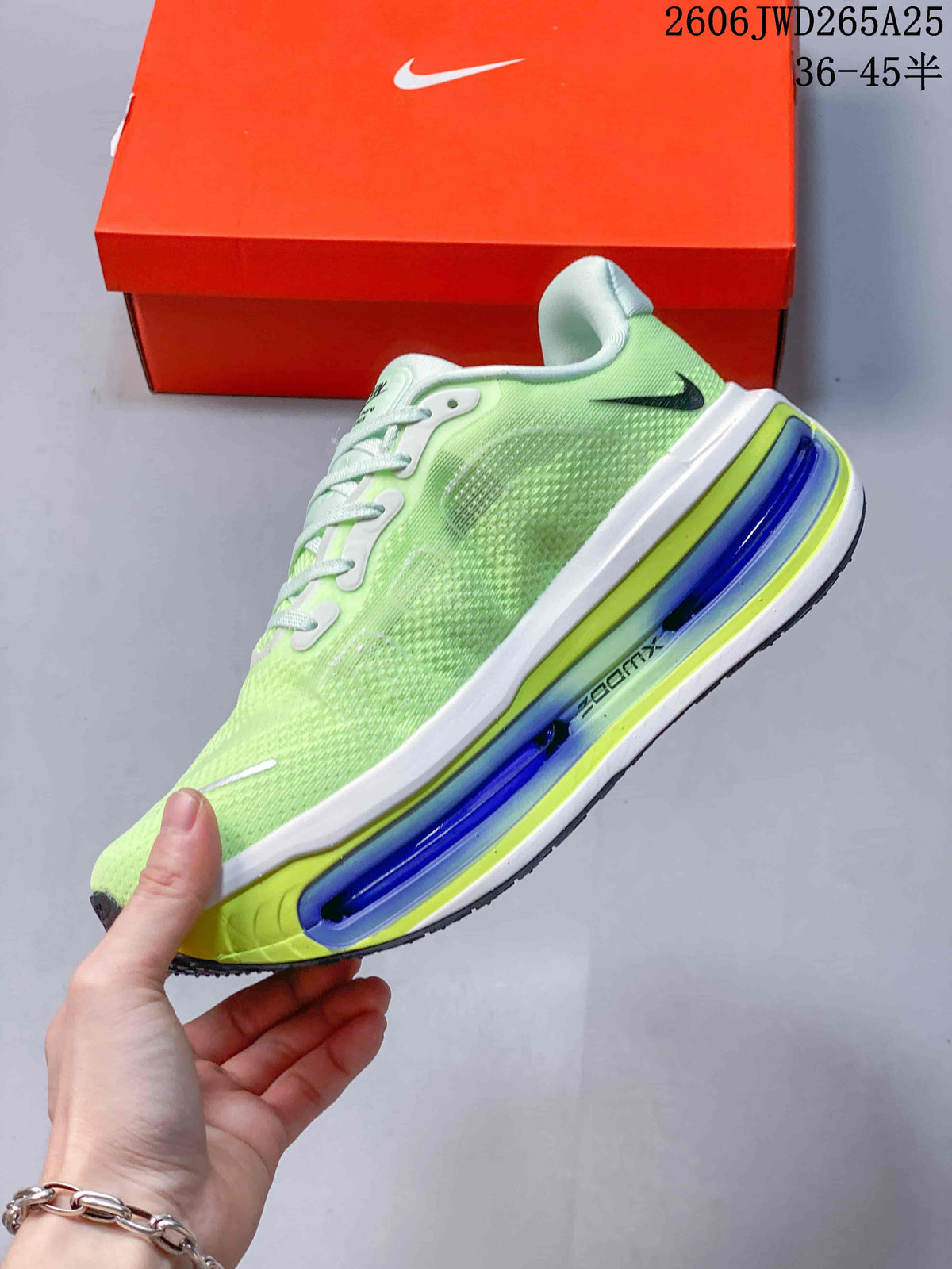 Side view of a lime-green Nike Vomero Premium shoe with a white midsole and visible blue and lime-colored sections.