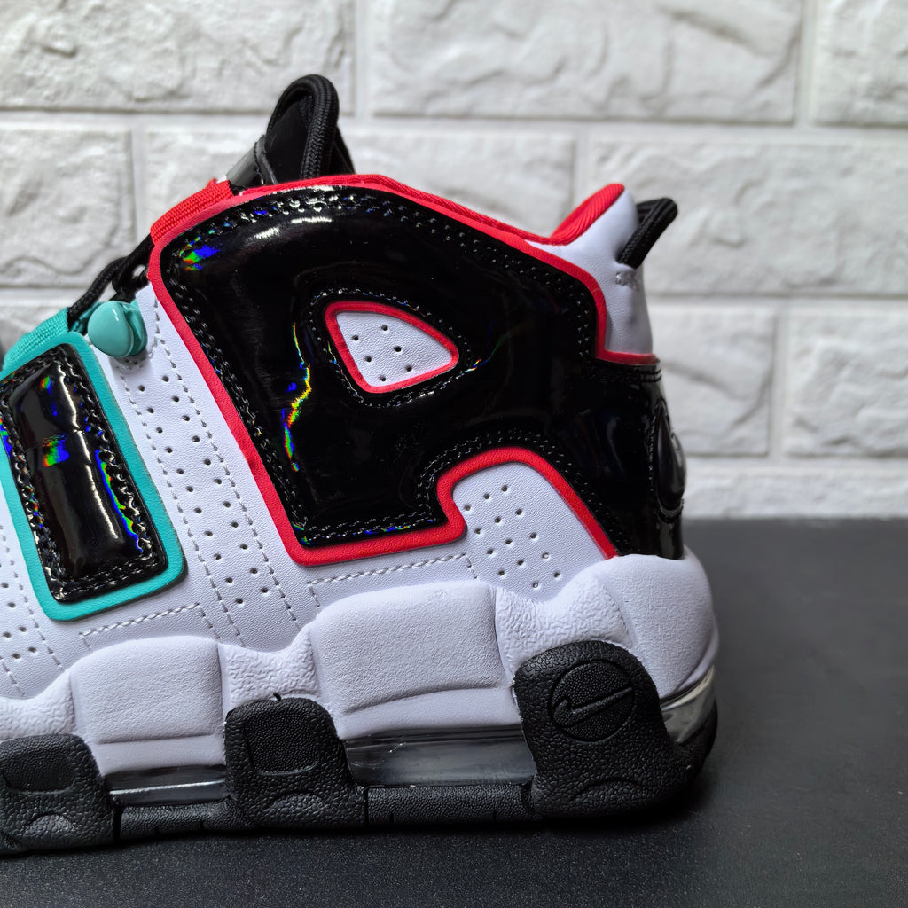Close-up of the glossy black heel-side panel with red trim and aqua details