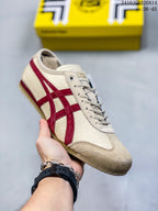 Angled side view of the cream and red sneaker showing the lace-up design, side stripes, toe overlay, and textured outsole.