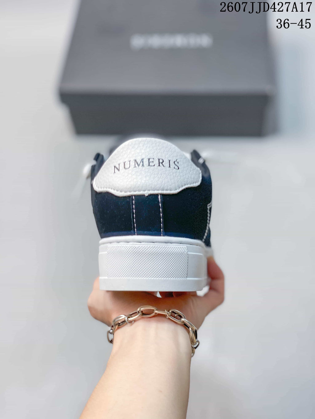 Rear view of a Numeris sneaker showing the white heel panel, navy upper, and branded heel detail.