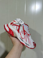 Angled top view of the white and red ASICS sneaker showing the mesh panels, overlays, laces, and red outsole details.