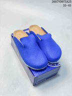 Blue closed-toe Amsterdam clogs displayed on a blue Birkenstock box.