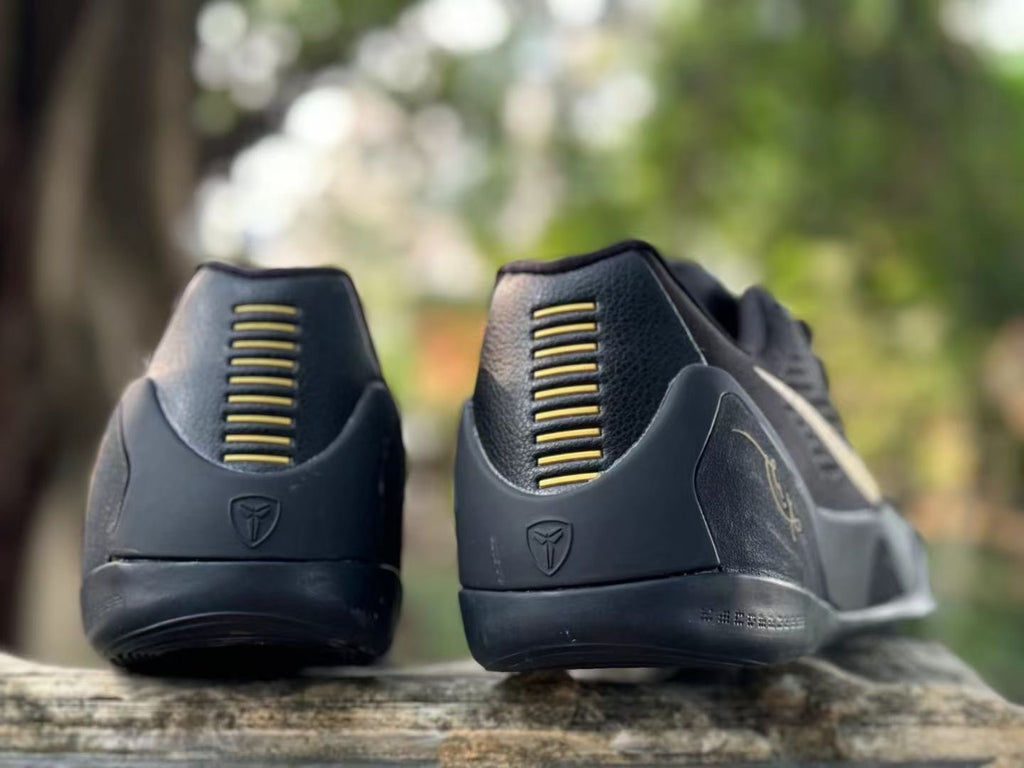 Rear view of black Kobe 9 shoes showing heel details and gold-toned accents.