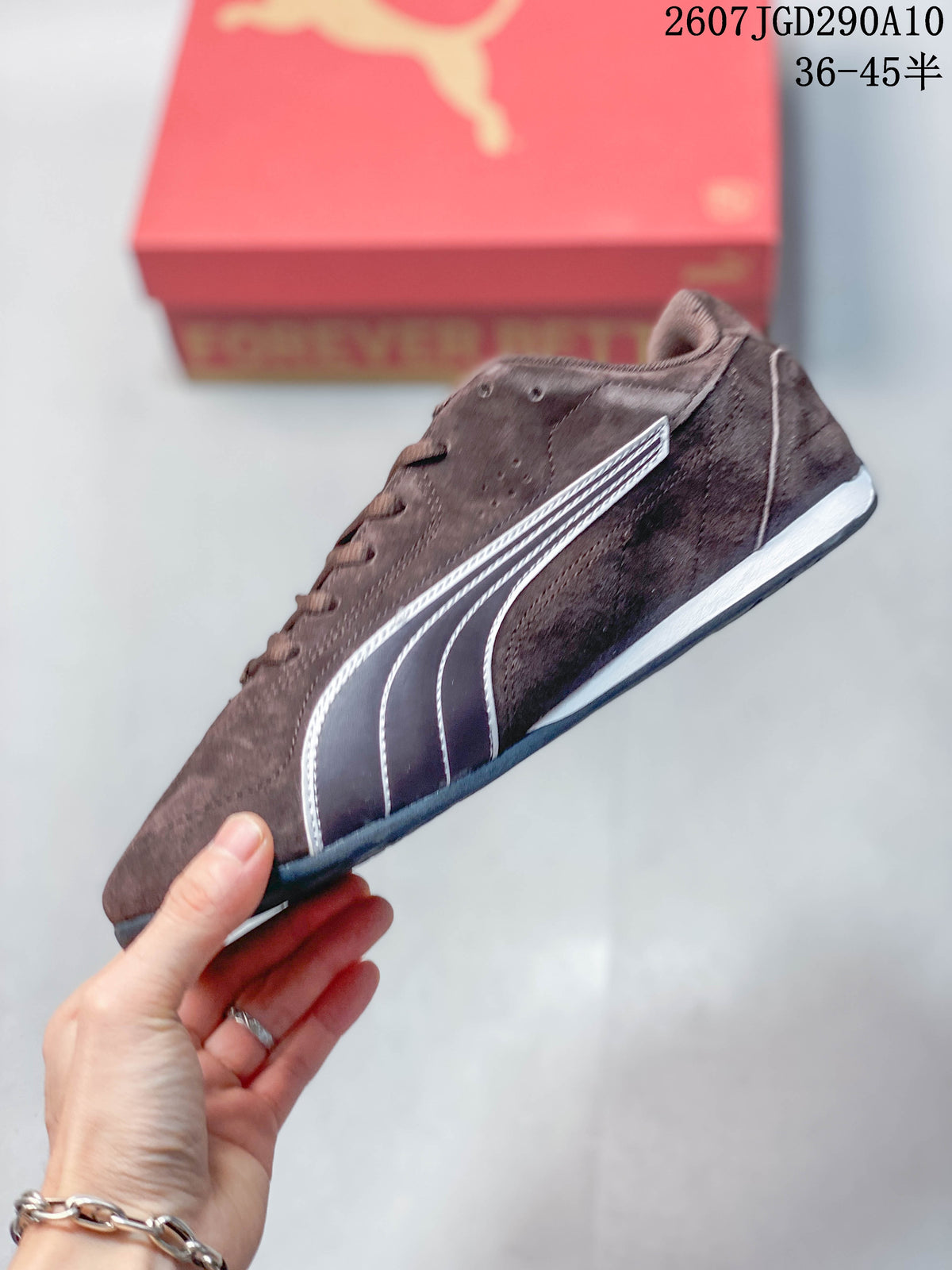 Side profile of the brown low-top sneaker showing the white Puma formstrip, low sole and lace-up construction.
