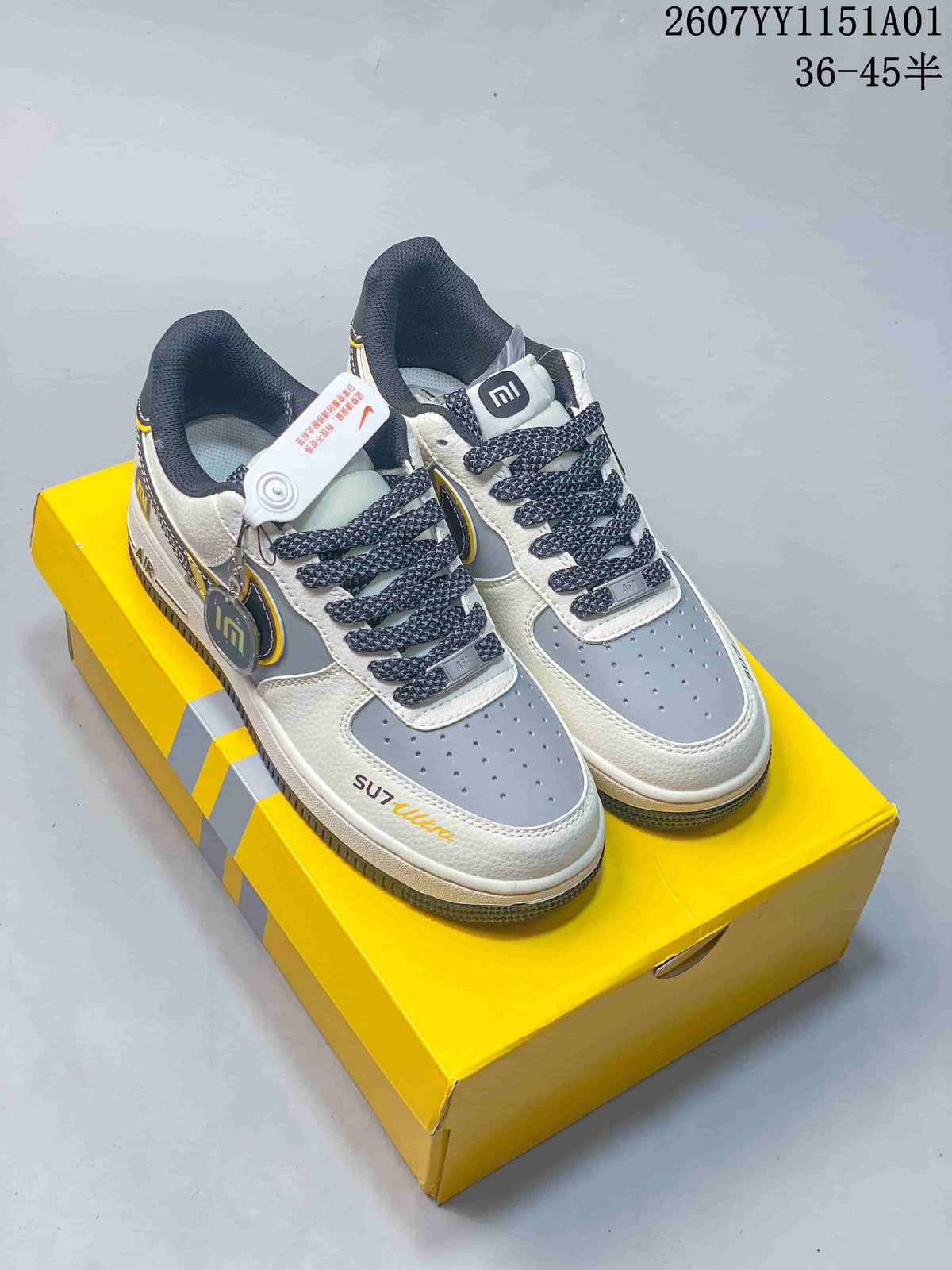 Pair of white, gray, and yellow low-top sneakers with SU7 Ultra and Xiaomi-themed details, shown on a yellow box.