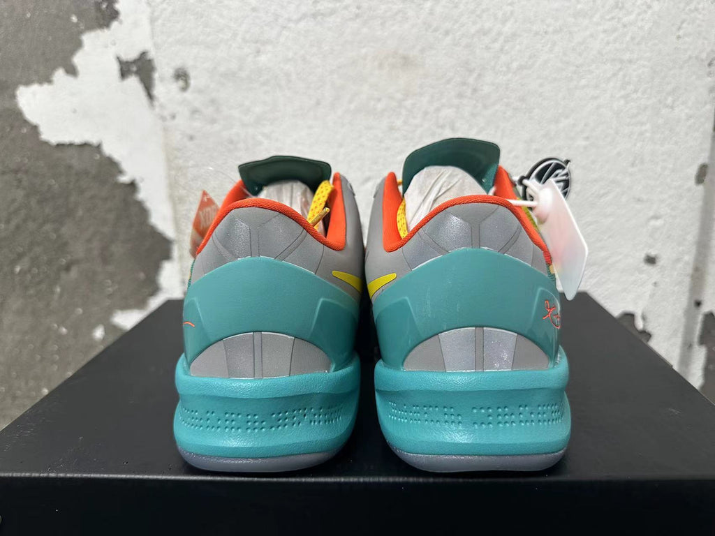 Rear view of multicolor Nike basketball shoes with turquoise heels and orange collar lining