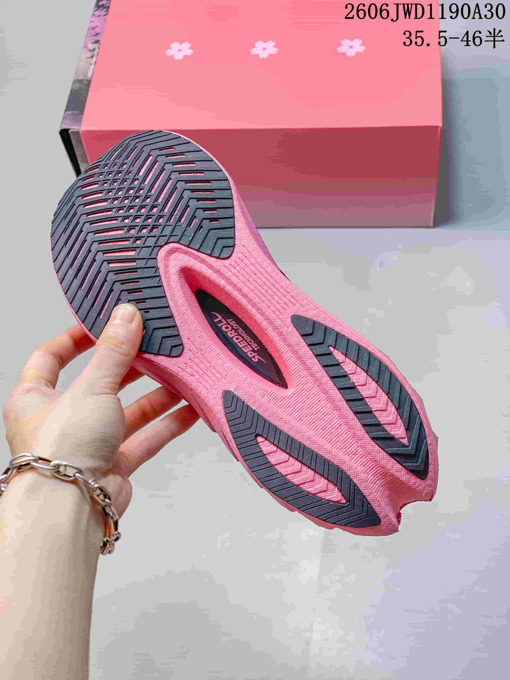 Underside of a running shoe showing the pink and dark patterned outsole