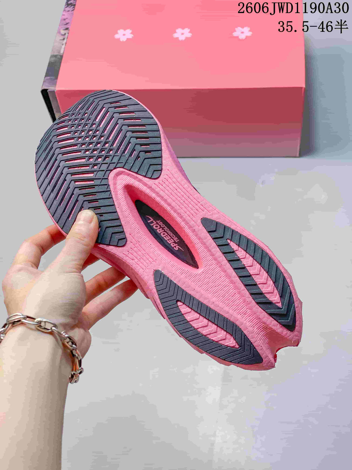 Underside of a running shoe showing the pink and dark patterned outsole