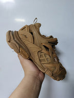 Close-up angled view of the camel sneaker’s side panels, mesh sections, branding, and chunky sole.