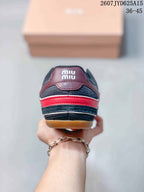 Rear view showing the burgundy heel panel, red horizontal accent and gum-colored outsole.