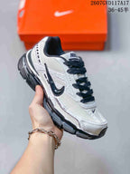Angled side view of the white and black Nike Initiator sneaker with its layered construction and thick sole.