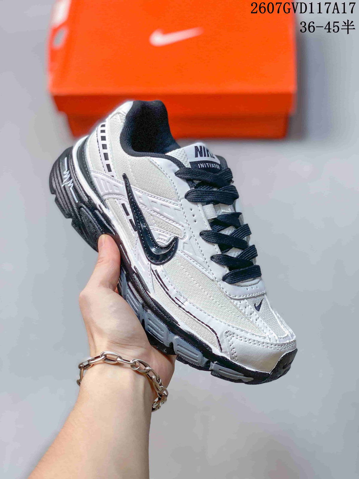 Angled side view of the white and black Nike Initiator sneaker with its layered construction and thick sole.