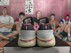 Rear view of white basketball shoes with black heel panels and pink accents