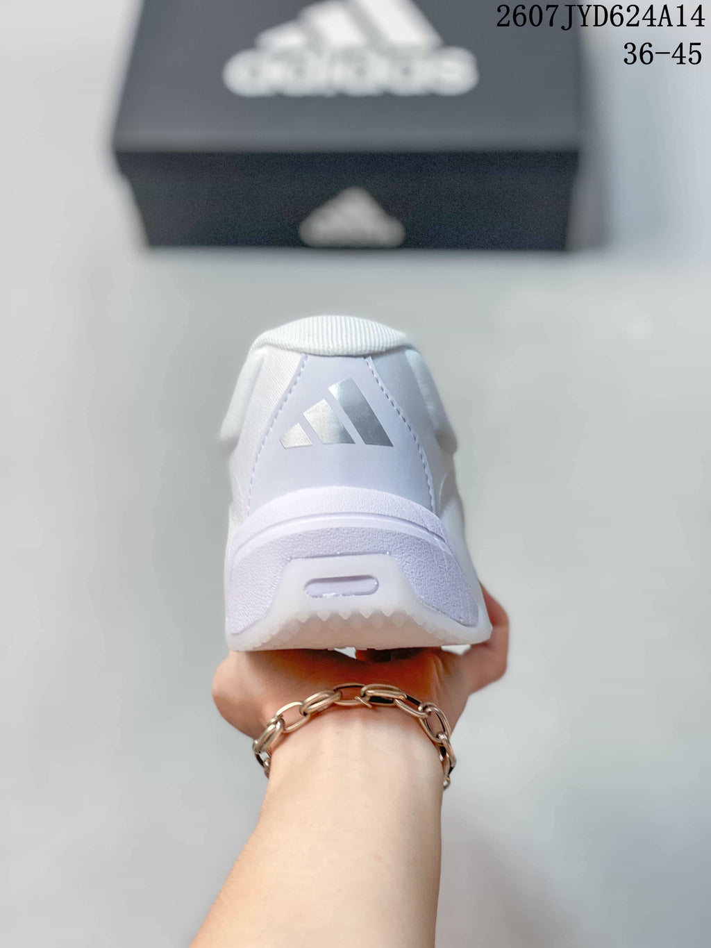 Rear view of a white adidas training shoe with the adidas logo on the heel.
