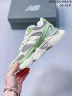 Side profile of the sneaker showing green and cream overlays, gray mesh panels, white branding, and a sculpted cream outsole.