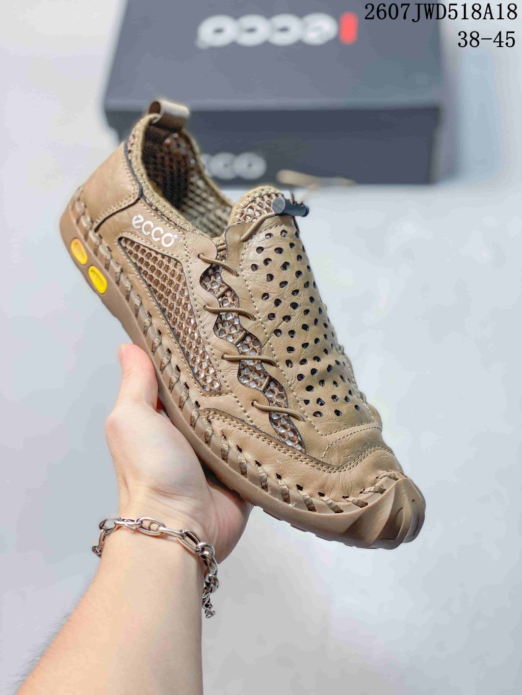 Three-quarter view of the tan ECCO sneaker showing side branding, perforated panels, mesh inserts and outsole details.