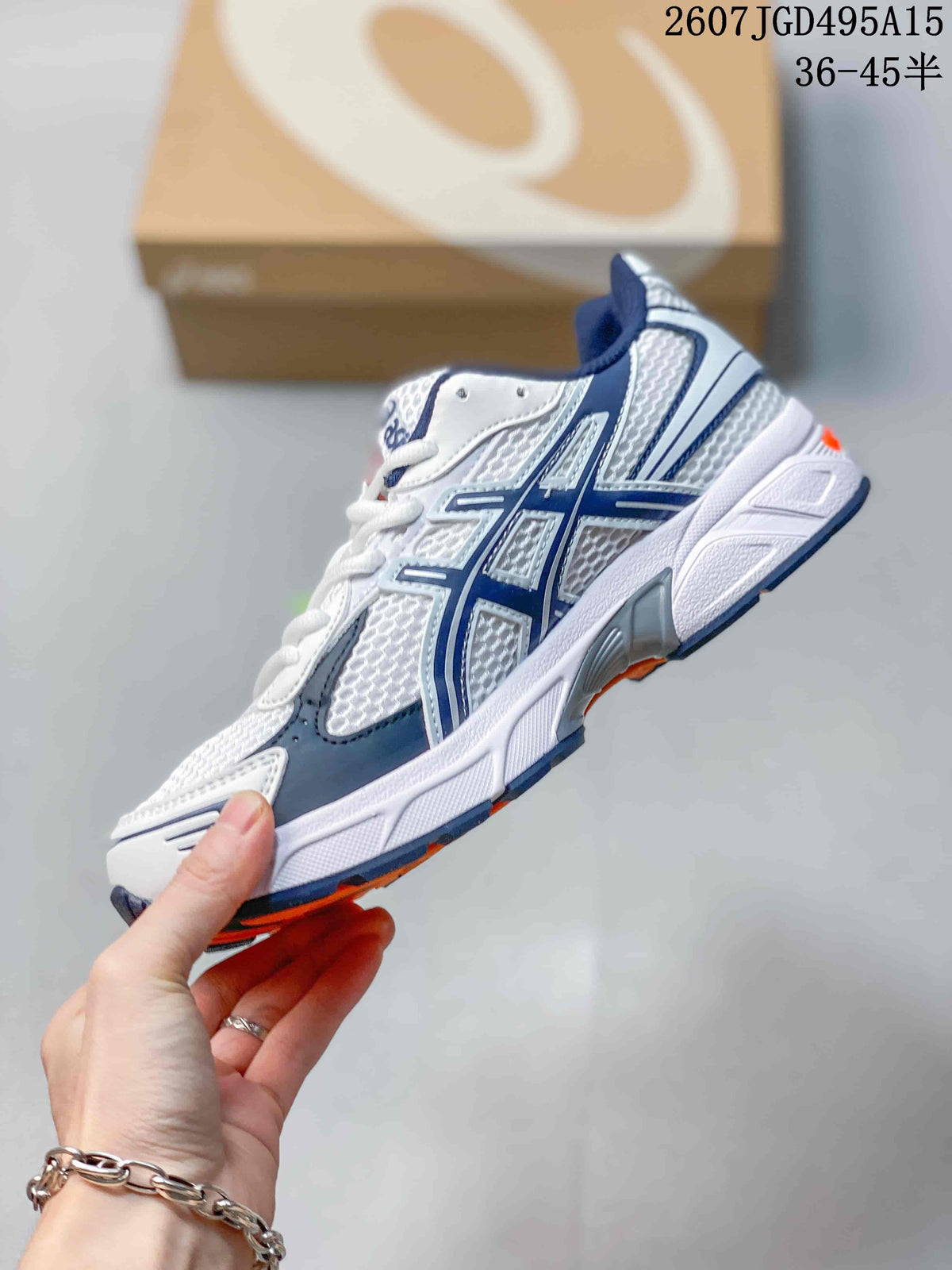Side view of the ASICS GEL-1130 sneaker showing white mesh-style panels, navy overlays and orange outsole accents.
