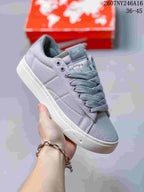 Angled front-side view of the gray Nike Blazer Low sneaker with white outsole, gray laces, and visible tongue branding.