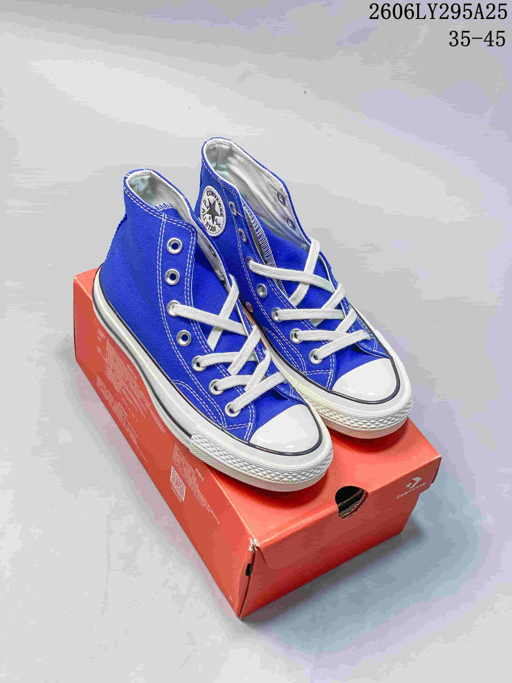 Blue Converse Chuck Taylor All Star high-top sneakers displayed on an orange shoebox; image text shows style code 2606LY295A25 and size range 35–45.