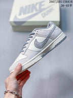 Side profile of an off-white Nike SB Dunk Low sneaker with a grey Swoosh, grey laces and layered panels.