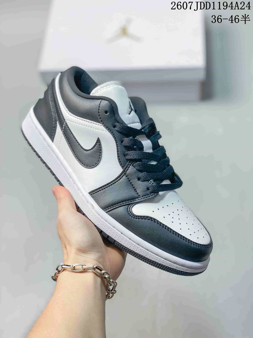 Black-and-white low-top Jordan sneaker shown from a front three-quarter angle, with a white toe box, black overlays, black laces, and a white midsole.