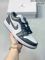 Black-and-white low-top Jordan sneaker shown from a front three-quarter angle, with a white toe box, black overlays, black laces, and a white midsole.