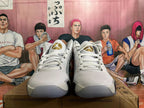 Front view of white and silver Jordan basketball shoes with gold-tone tongue details