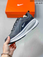 Side profile of the dark gray and white running shoe showing the Swoosh logo, layered midsole, and textured upper.
